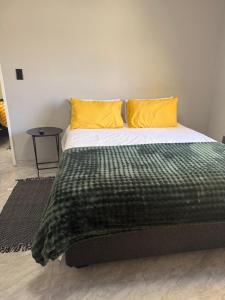 a bed with two yellow pillows on top of it at J&A Corner - Swakopmund in Swakopmund