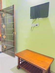 a wooden bench with a television on a wall at RASHI Lodge Attibale in Attibele