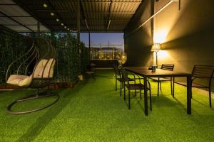 a room with green grass and a table and chairs at After Hours Guesthouse Self Check-in in Bangkok