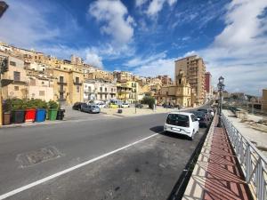 a white car parked on the side of a city street at Il Sole e La Luna in Agrigento