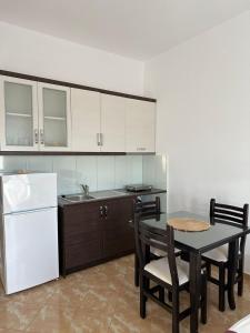 a kitchen with a table and a white refrigerator at Seli's White Villa in Ksamil
