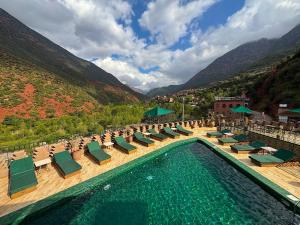 a pool with chaise lounge chairs and a bunch of mountains at La Kasbah d'Ourika - Hôtel Restaurant & Spa in Ourika