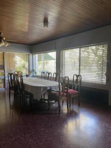 a dining room with a table and chairs and windows at Chalet de Irurtia in Carmelo +10 photos