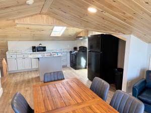 a kitchen with a table and a black refrigerator at Abellona Inn & Suites in Old Orchard Beach