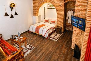 a bedroom with a bed and a tv in a room at Riad O LY in Marrakesh +118 photos