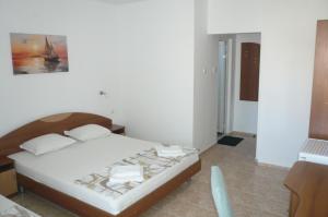 a bedroom with a bed with white sheets at Къща за гости Мишел in Nesebar