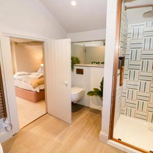 a bedroom with a bed and a bathroom with a toilet at Bay House in Broadway +98 photos