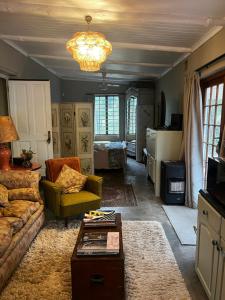 a living room with a couch and a table at Greyton Cottage in Greyton