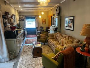 a living room with a couch and a kitchen at Greyton Cottage in Greyton