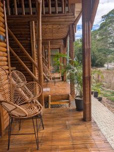 a porch of a wooden cabin with chairs and a bench at Jadens Guesthouse in Siquijor