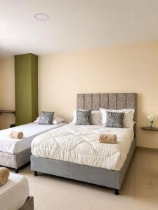 a bedroom with two beds with pillows on them at Fuscaldo Hotel in Valledupar