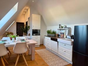 a kitchen with white cabinets and a table with a dining room at Wohnung Dorfblick in Hauenstein