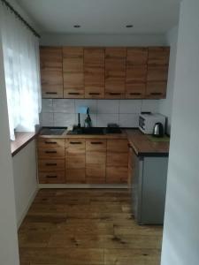 a kitchen with wooden cabinets and a counter top at Chatka Czesia in Sosnówka