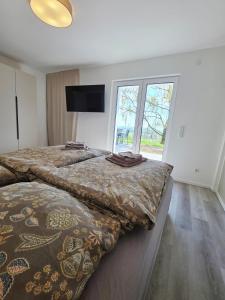 two beds in a room with a window at Panorama trifft Gemütlichkeit FeWo Panoramablick in Nümbrecht