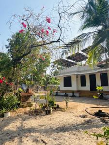 a building with trees and flowers in front of it at Nature Heritage by Marari in Mararikulam