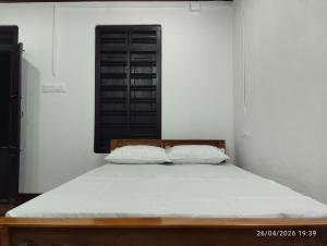 a bedroom with a bed with two pillows on it at Nature Heritage by Marari in Mararikulam