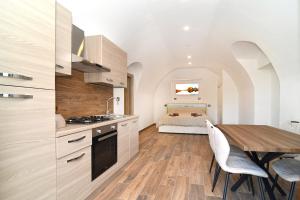 a kitchen and dining room with a table and a bed at CáMillina in Santa Maria Maggiore