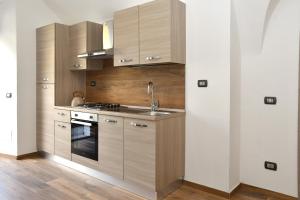a kitchen with wooden cabinets and a sink at CáMillina in Santa Maria Maggiore +6 photos