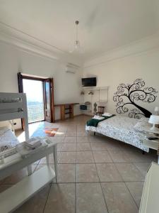 a large room with two beds and a television at La Petra in Vico Equense