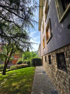 a stone building with a pathway next to a yard at B&B Del Paradiso in Bergamo
