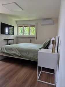 a bedroom with a large bed and a white table at B&B Del Paradiso in Bergamo