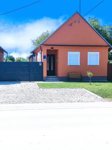 a orange house with a bench in front of it at Apartman LIPA-Lipovac Bajakovo! Parking,Wi-Fi in Lipovac