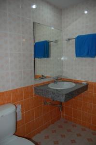 een badkamer met een wastafel, een toilet en een spiegel bij Baan Manthana House in Hua Hin