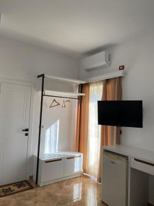 a living room with a tv and a door with a window at Seli's White Villa in Ksamil