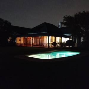 a house at night with a pool in front of it at Lekkerrus guesthouse in Krugersdorp