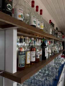 a shelf filled with bottles of alcohol and glasses at Kuba pansiyon in Side