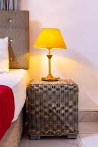 a lamp on a wicker table next to a bed at Artist sanctuary lakeview phase4 in Mto Panga