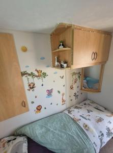 a childs bedroom with a bunk bed with butterflies on the wall at Jams Caravan in Skegness
