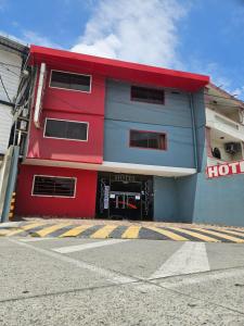 a red and blue building with a hotel at Hotel Confort in Guayaquil