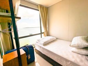a small room with a bed and a window at Lovina 20-AE at One Residence in Batam Center +16 photos