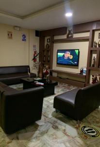 a living room with couches and a flat screen tv at Hotel Confort in Guayaquil +14 photos