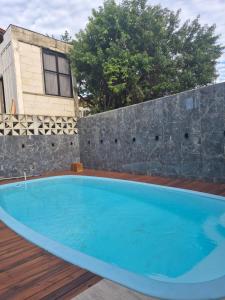 a large blue swimming pool on a wooden deck at Beach House Delegado Marcio in Balneário Camboriú