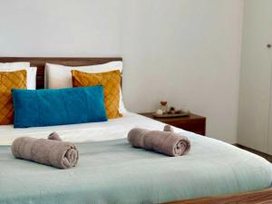 a bed with two rolled towels on top of it at Coastal 2BR Apt in Mackenzie Steps from Beach by Cyprus Horizons in Scala +9 photos