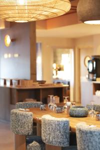 ein Holztisch mit Stühlen in einem Restaurant in der Unterkunft Casa C Hôtel & Spa in Propriano