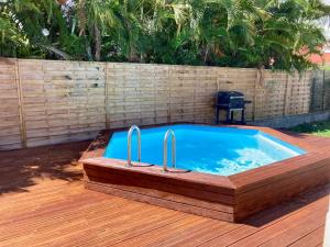 a hot tub sitting on a deck with a wooden floor at Villa SELAH in Le Moule