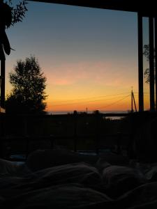 a sunset seen from a bed in front of a window at Høgberget Loft with 3 bedrooms and private bathroom in Skotten