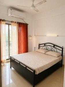 a bedroom with a bed in a room with a window at Sk Holiday Apartment in Alibaug