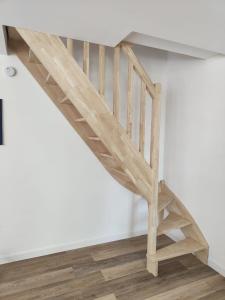 a wooden staircase in a room with white walls at Gîte du Tilleul in Beire-le-Châtel