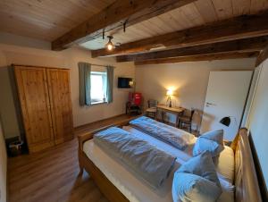 a bedroom with two beds and a table and a desk at Pension Müllers Mühle in Großenhain