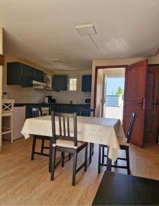 a kitchen and dining room with a table and chairs at Gîte au coeur du pays dinannais in Plumaudan
