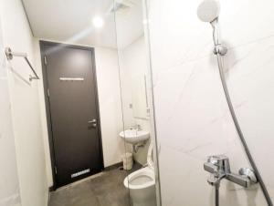 a bathroom with a toilet and a black door at Lovina 3-AH at One Residence in Batam Center +9 photos