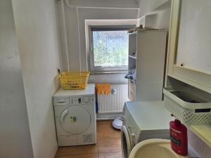 a small kitchen with a washing machine and a window at Ferienwohnung Anja in Sonneberg