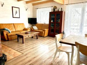 a living room with a couch and a table at Dom wakacyjny nad jeziorem, Mazury in Samin