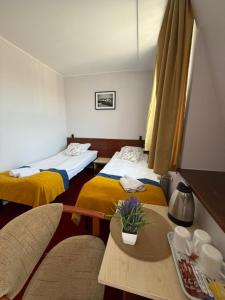 a hotel room with two beds and a table at Hotel Aleksander in Ustka +83 photos