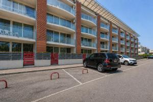 a car parked in a parking lot in front of a building at Vacanze Residence Mimose - con parcheggio relax tra pineta e spiaggia in Eraclea Mare