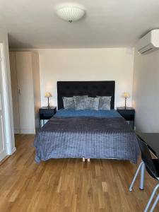 a bedroom with a bed with a blue comforter at Fully equipped guest apartment with parking in Upplands-Väsby